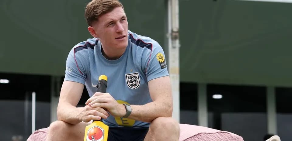 Player sitting on a couch holding a cricket bat