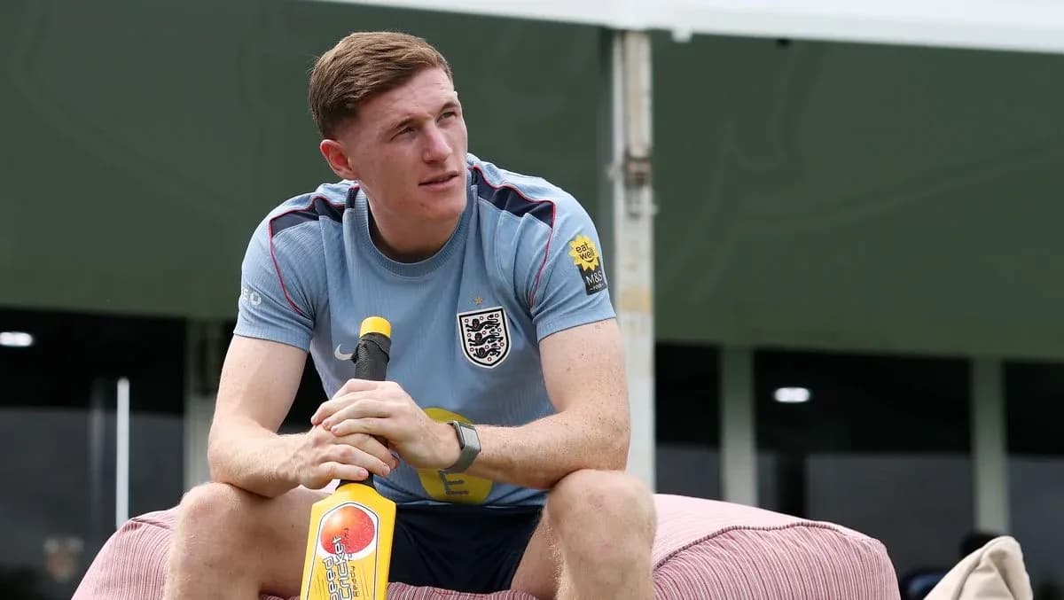 Player sitting on a couch holding a cricket bat