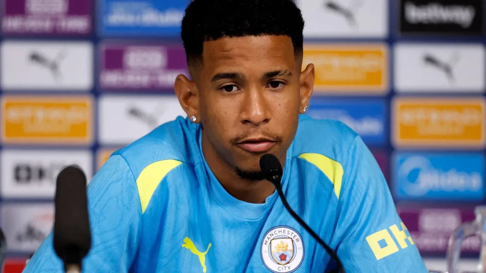 Player at press conference wearing Manchester City kit