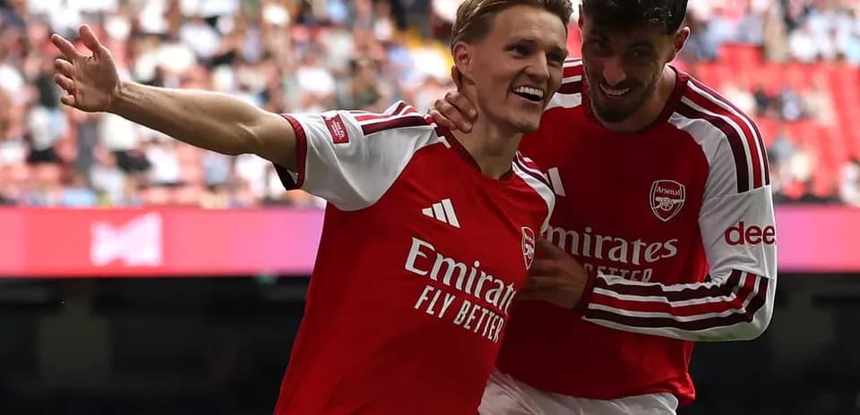 Two Arsenal players celebrating a goal on field
