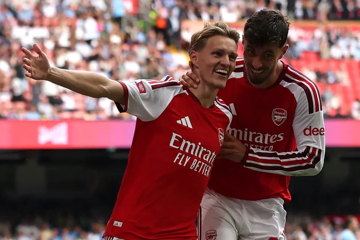Two Arsenal players celebrating a goal on field