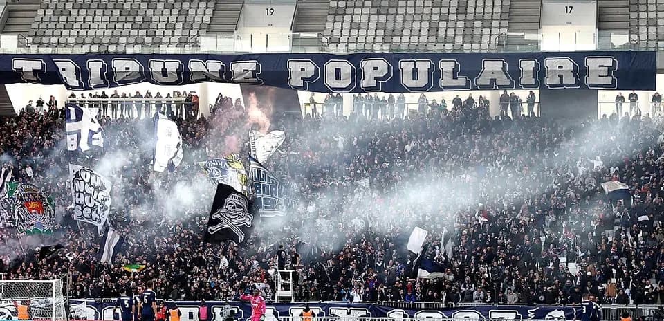 Crowd of fans waving flags and banners in stadium