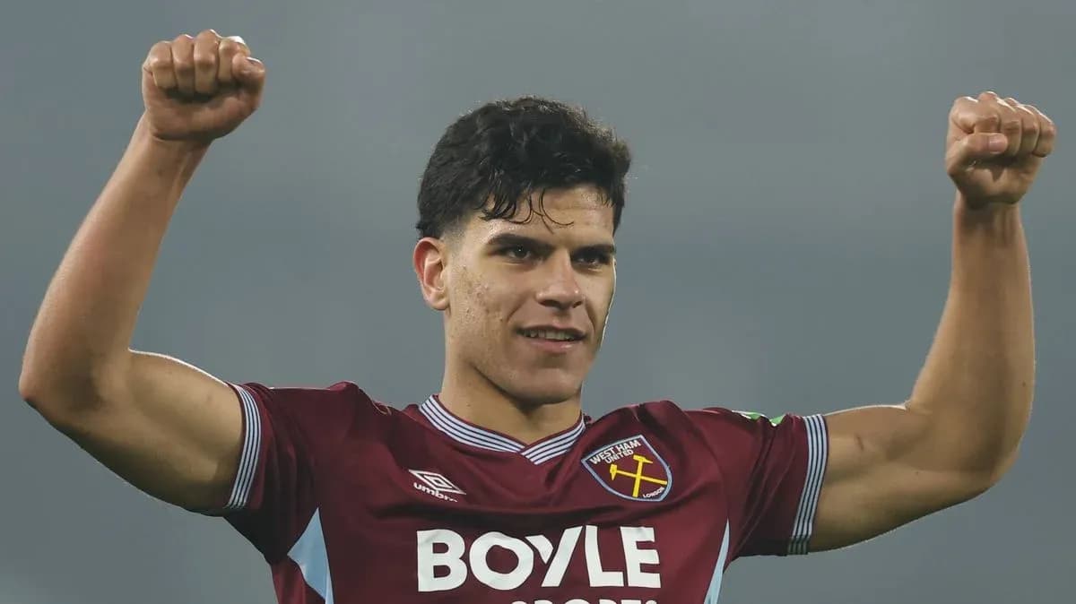Player celebrating with raised arms in team jersey