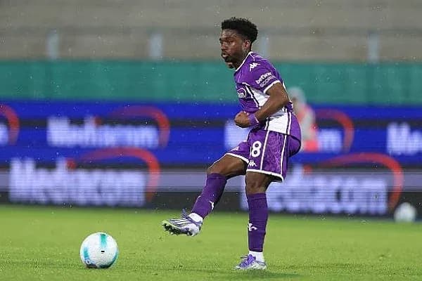 Player in purple kit kicking a soccer ball