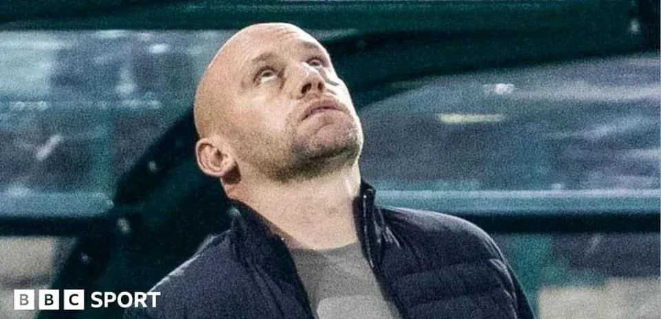 Coach looking up from the technical area