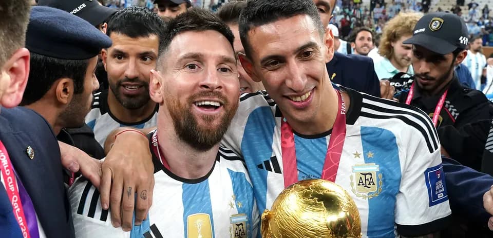 Messi and Di Maria celebrating with FIFA World Cup trophy