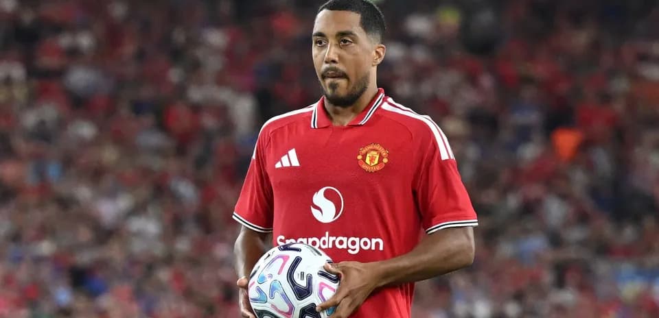 Player holding the ball in Manchester United jersey