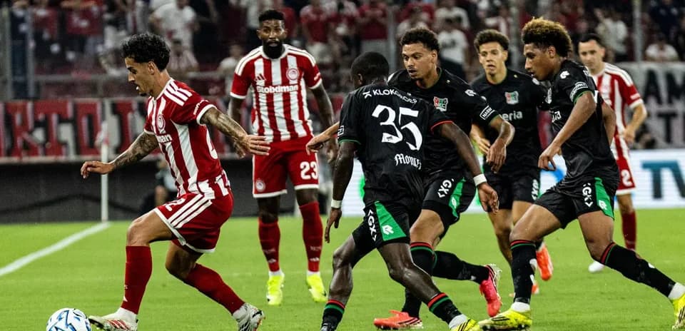 Olympiakos Piraeus player dribbling past NEC Nijmegen defenders