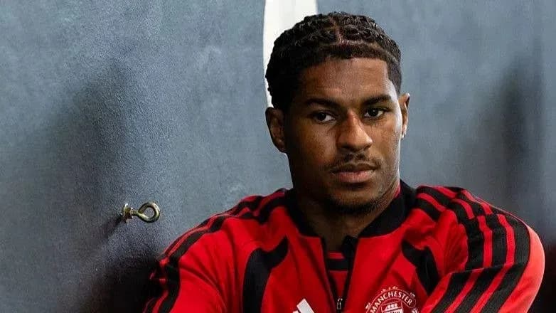 Football player sitting against wall in training gear