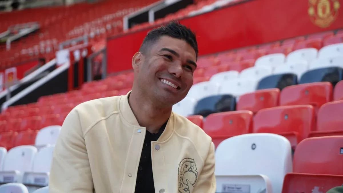 Player seated in empty stadium stands, smiling