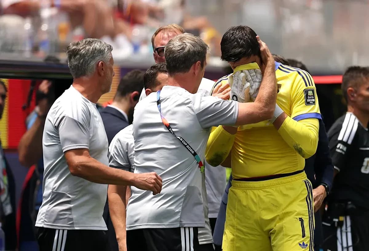 Goalkeeper receiving support from coaching staff on sidelines