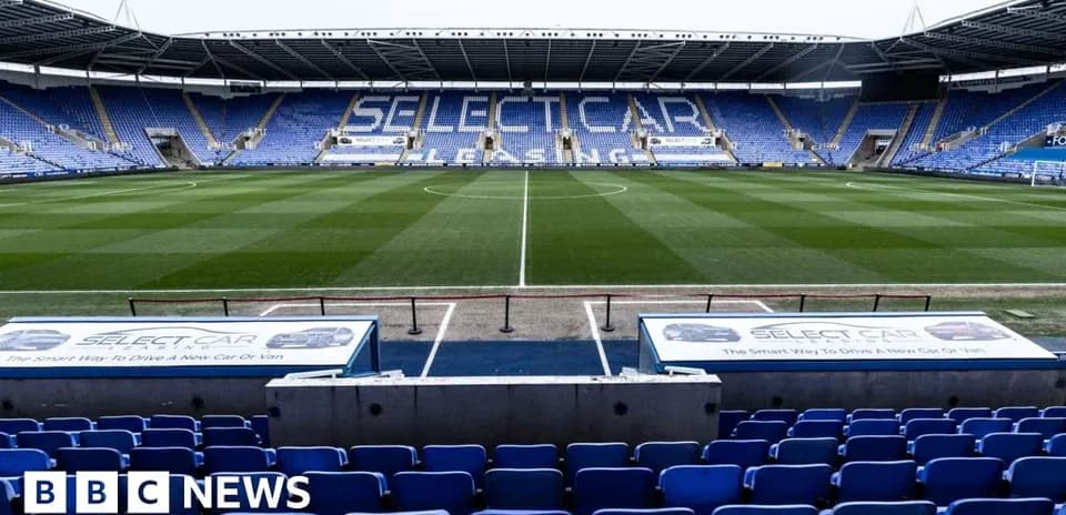 Empty football stadium with blue seating and field