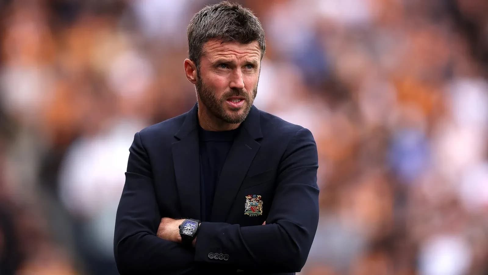 Coach observing the match with arms crossed