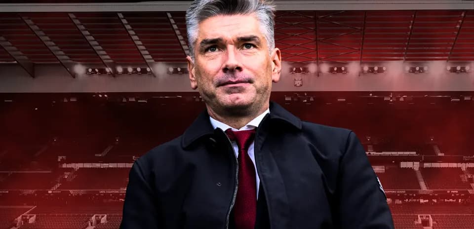 Manager standing in stadium with red background