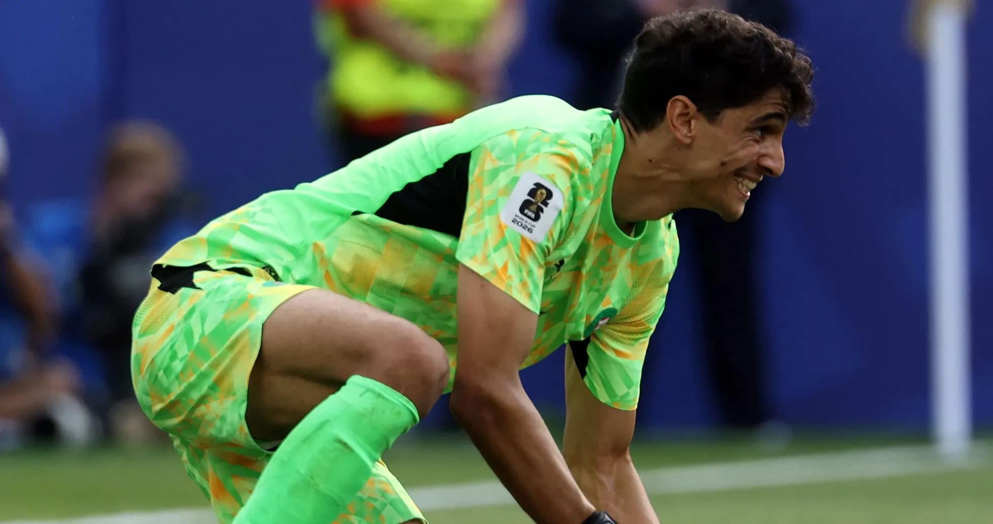 Goalkeeper in green kit preparing to make a save