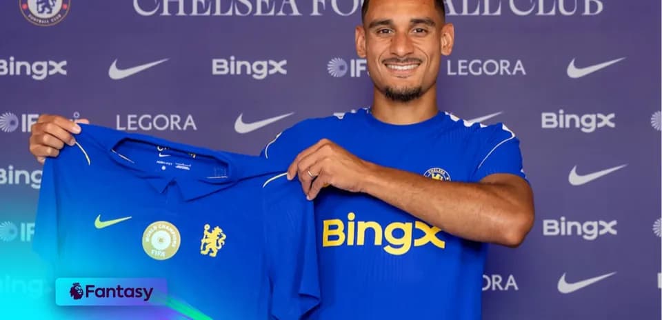 Player holding Chelsea jersey at press conference