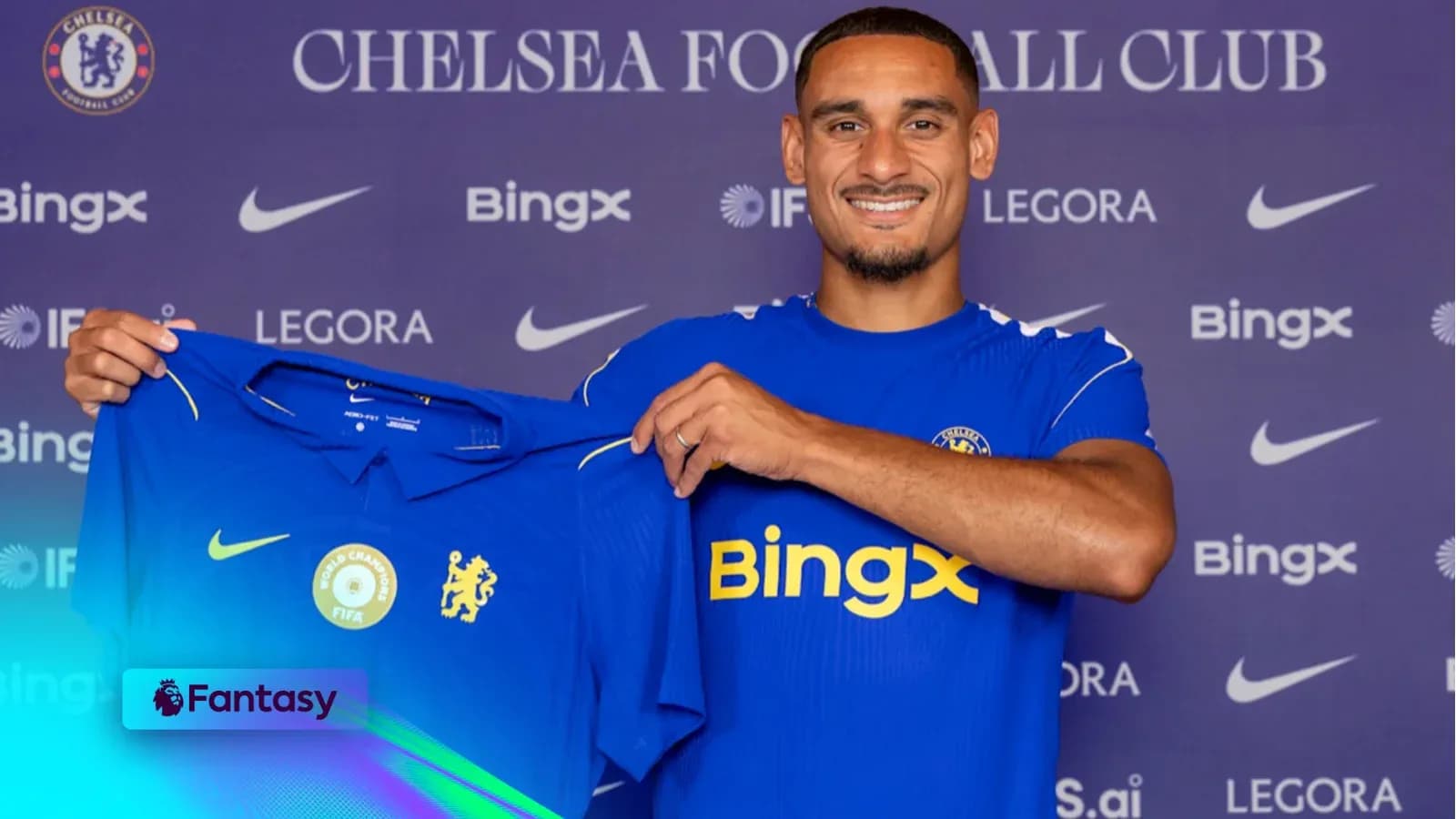 Player holding Chelsea jersey at press conference