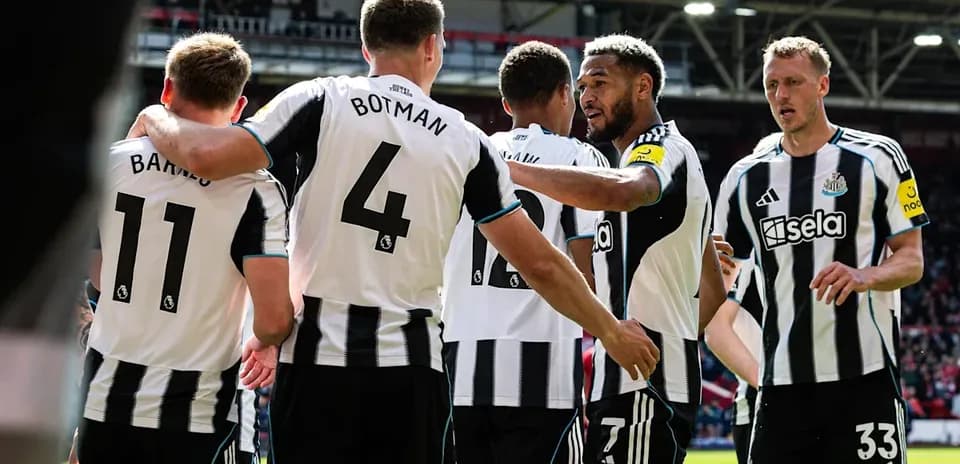 Newcastle players celebrating together on the pitch