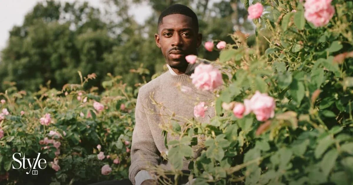 Man sitting among pink roses in garden
