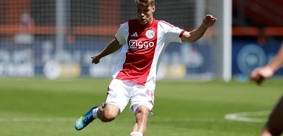 Player in Ajax kit striking the ball on field