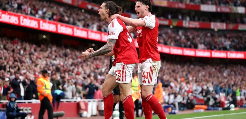 Two Arsenal players celebrating a goal at Emirates Stadium