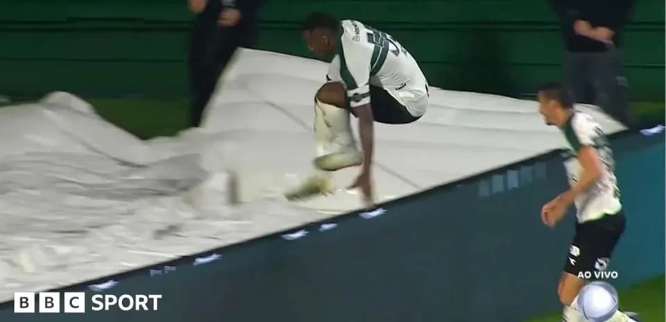 Player jumping over protective tarpaulin during match