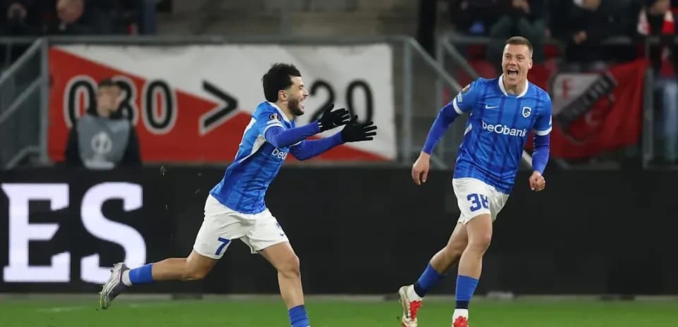 Two players celebrating a goal in blue uniforms