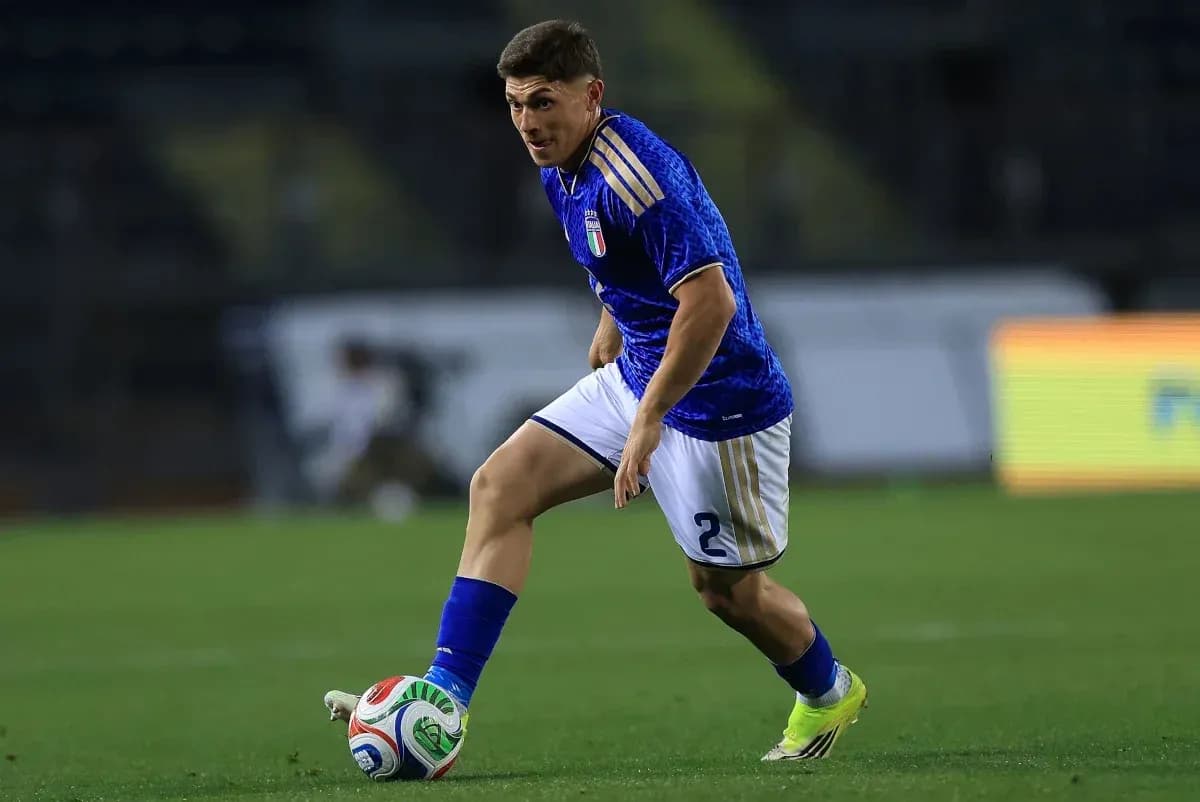Player in blue jersey dribbling ball on field