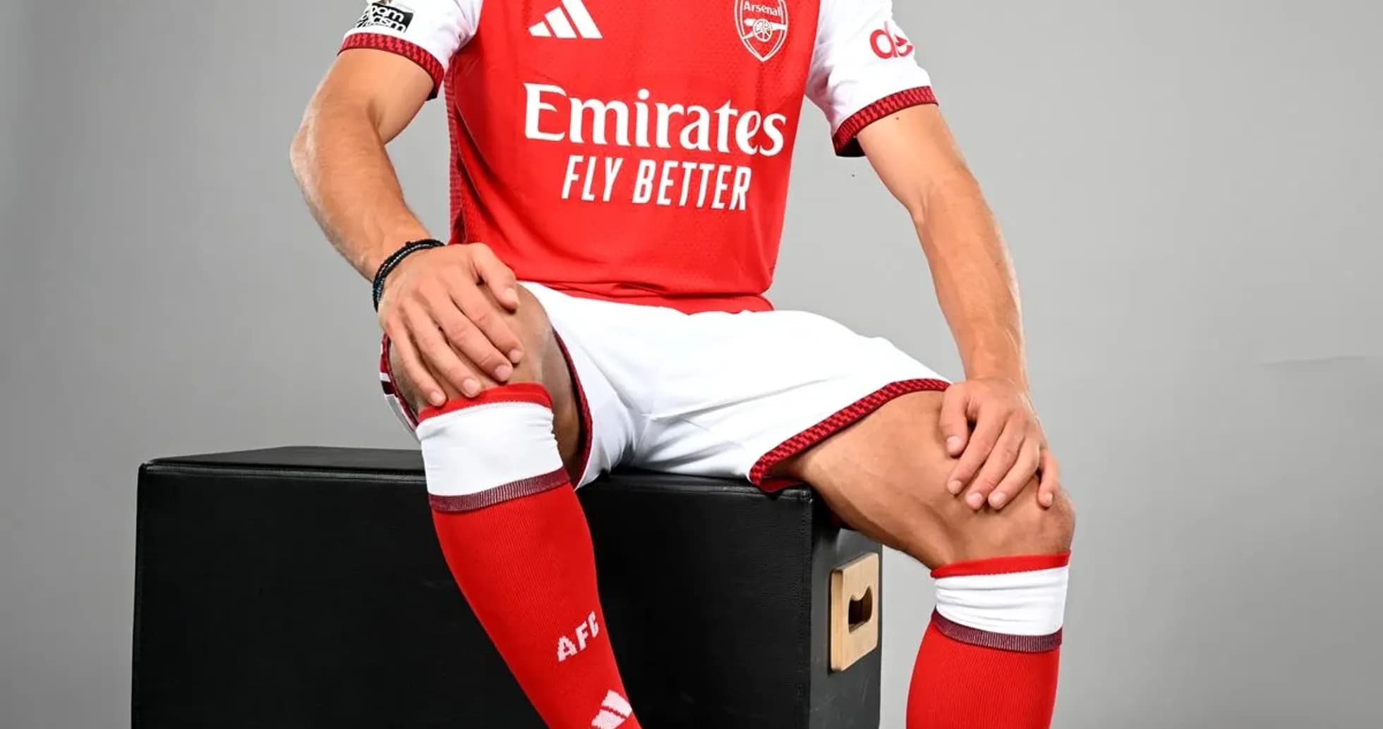 Player in Arsenal kit posing with football