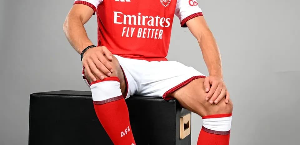 Player in Arsenal kit posing with football