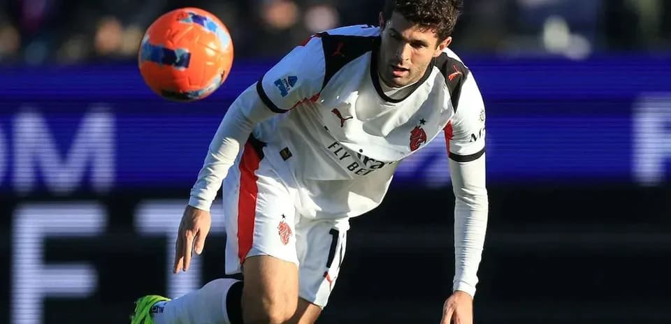 Player in white jersey reaching for airborne soccer ball