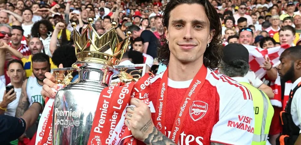 Player holding Premier League trophy surrounded by fans