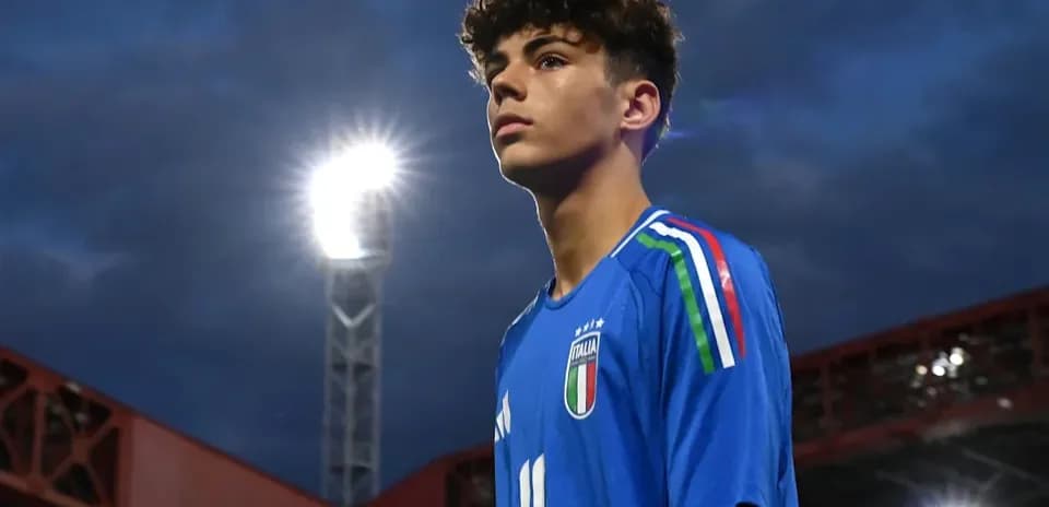 Player in blue Italy jersey under stadium lights