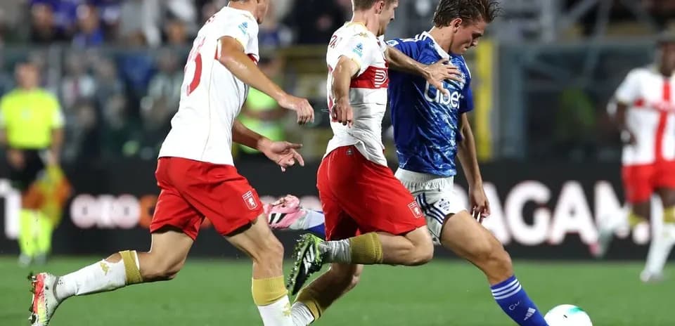 Genoa players challenging for the ball against Como