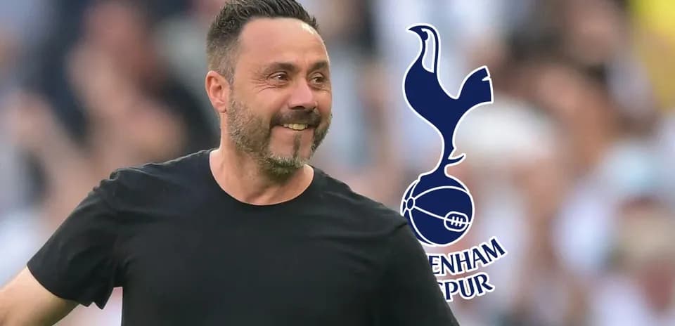 Manager smiling during match with Tottenham logo