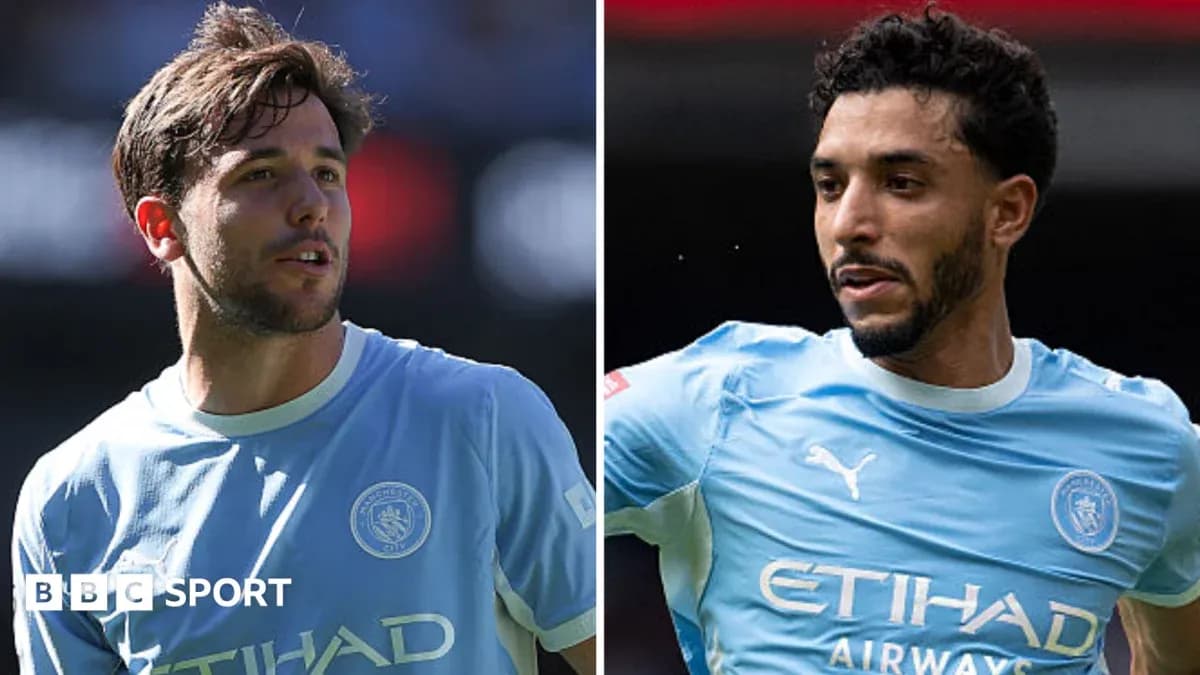 Two Manchester City players in light blue jerseys