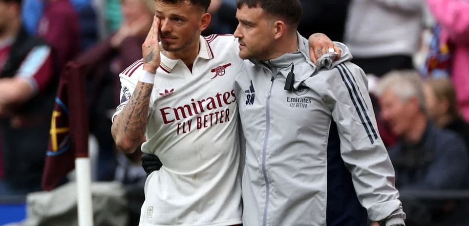 Player being assisted off the field by staff