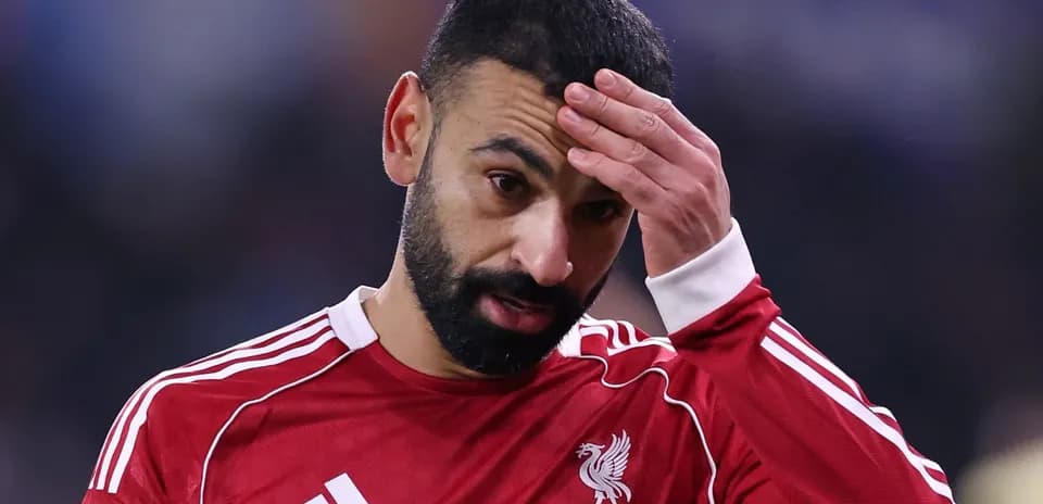 Player in red jersey touching forehead during match