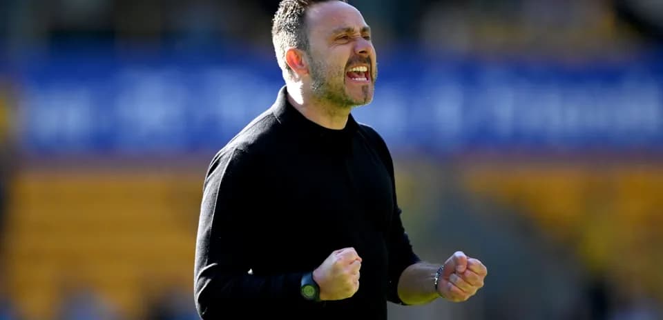 Manager celebrating with clenched fists on the sidelines