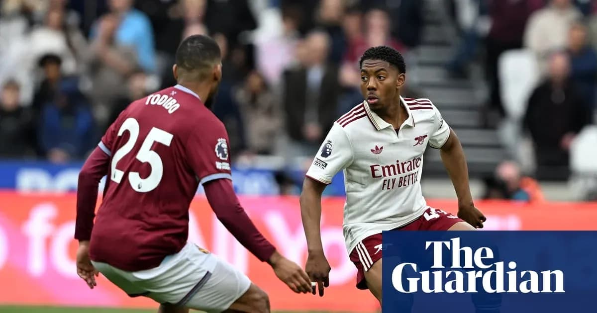 Arsenal player dribbling past opponent during match
