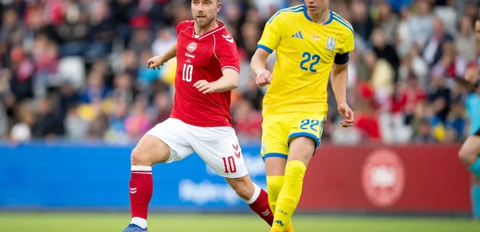 Players from Denmark and Ukraine competing for the ball