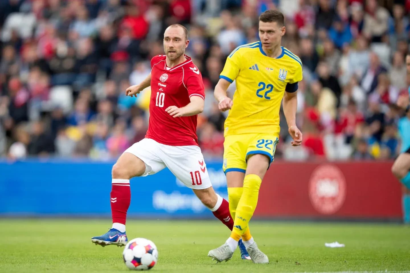 Players from Denmark and Ukraine competing for the ball