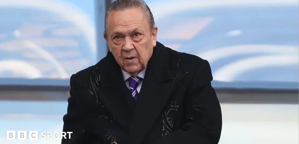 Man in a black coat at sporting event