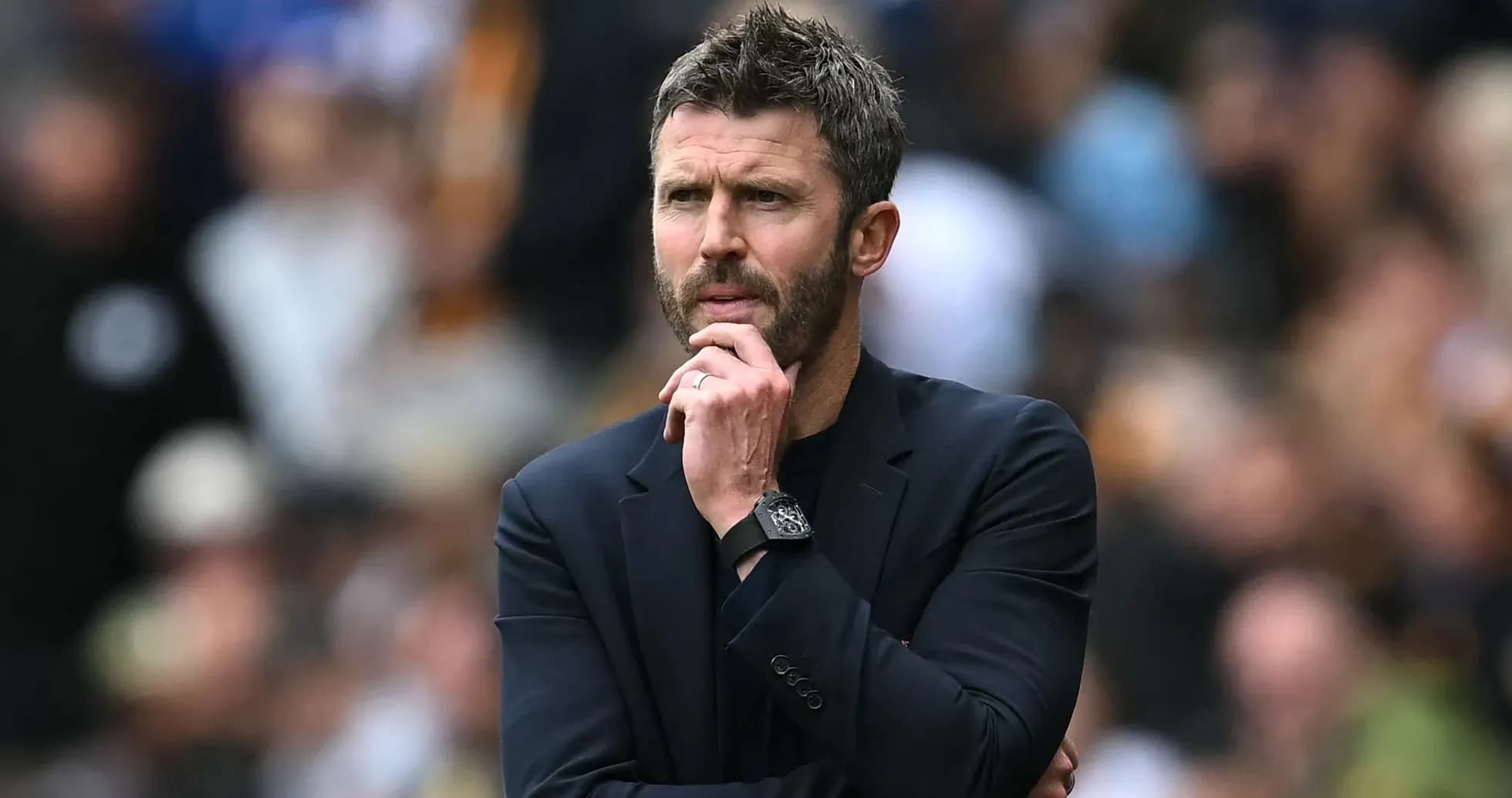 Coach observing match with thoughtful expression
