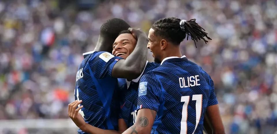 Three players celebrating a goal on the field