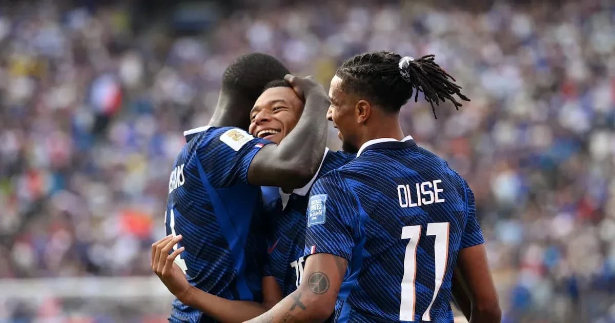 Three players celebrating a goal on the field