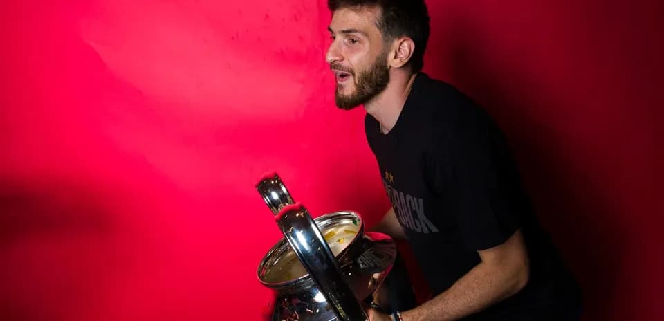 Player holding a trophy against a red background