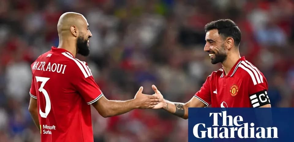 Two Manchester United players shaking hands on field