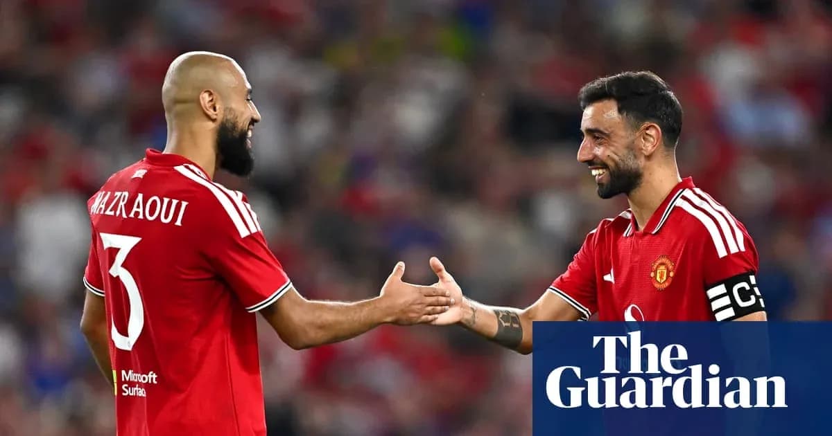 Two Manchester United players shaking hands on field