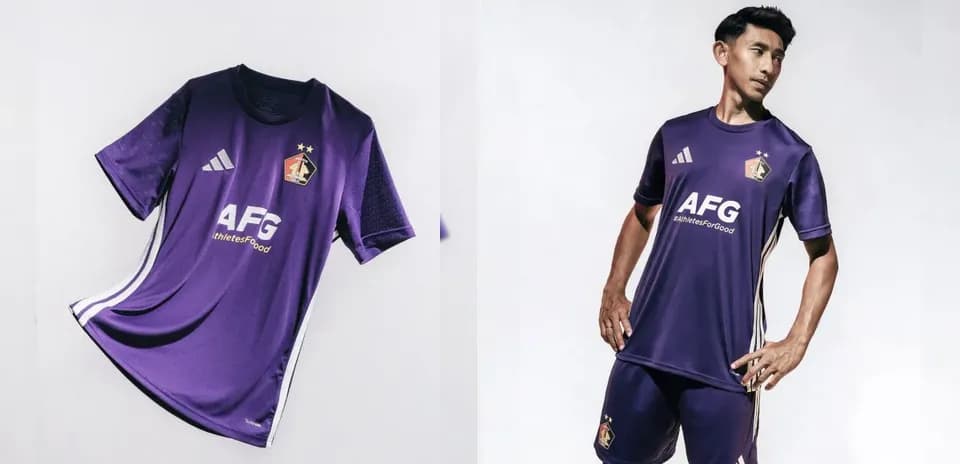 Player modeling purple football kit with logo
